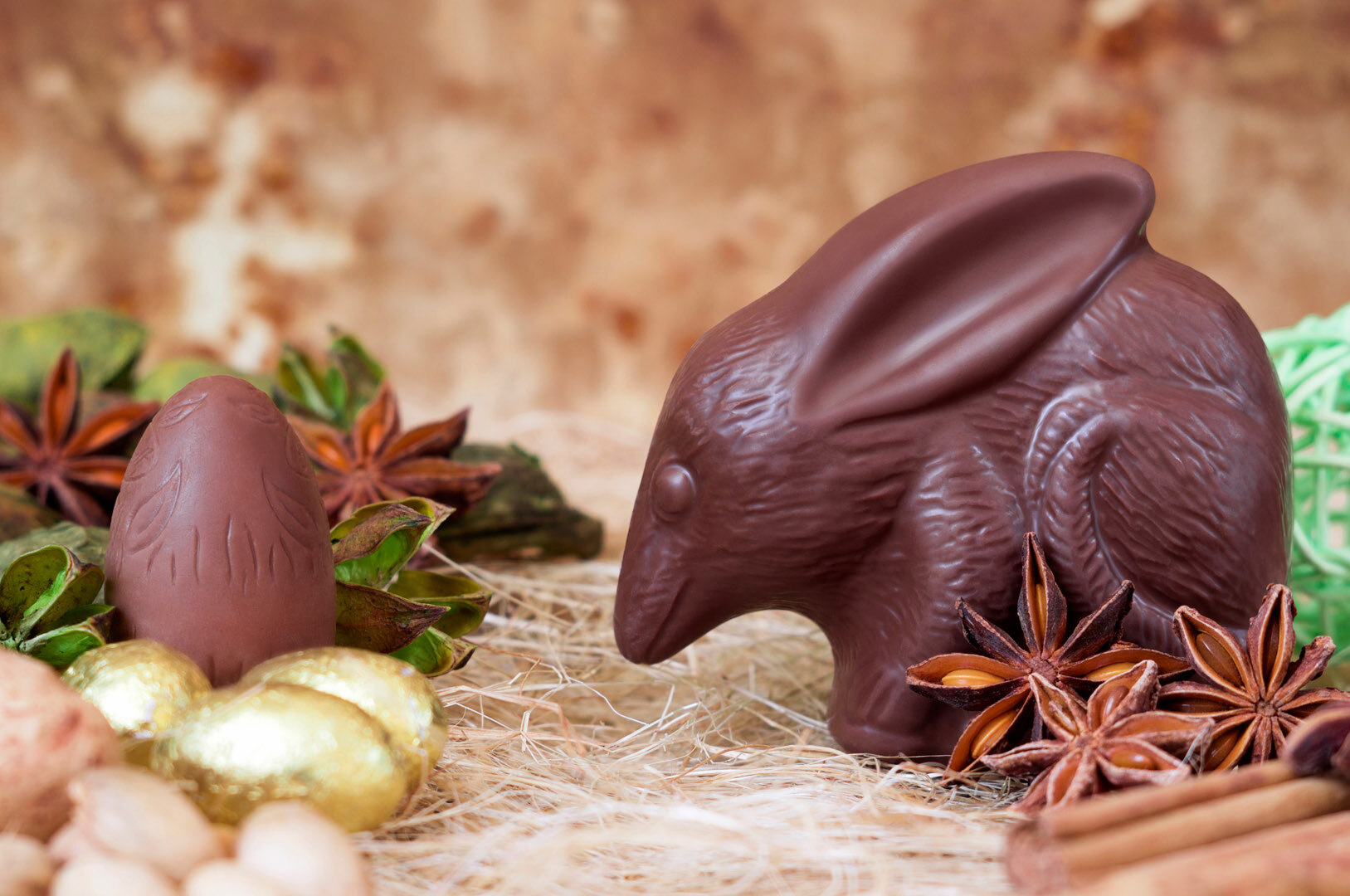 Ein hasenähnliches Tier aus Schokolade sitzt auf Stroh. 