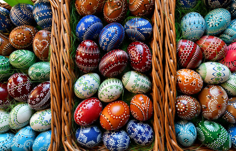 Colourful Easter eggs are lying in a wicker basket.