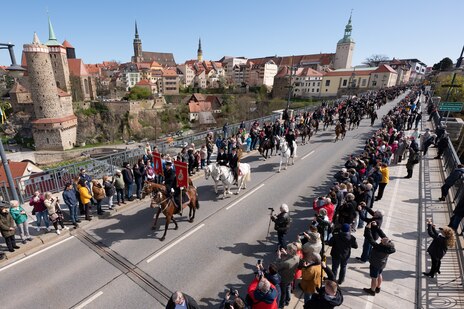 Männer reiten auf Pferden durch eine Stadt. 