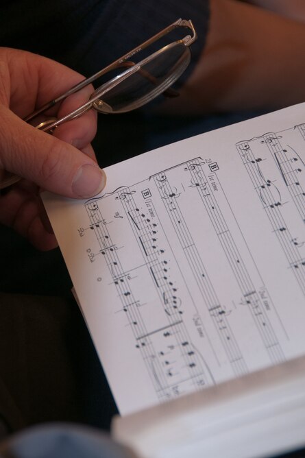 Ein Chorsänger hält sein Notenheft in der Hand.
