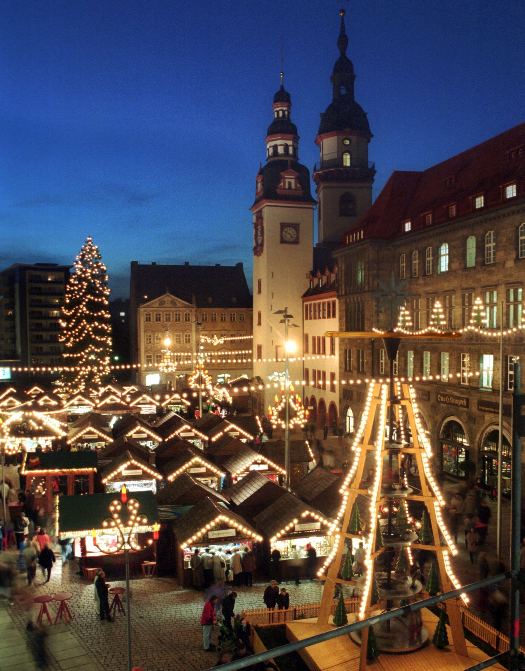 Eine Vielzahl geschmückter Weihnachtsmarktbuden leuchten vor dem Rathaus der Stadt Chemnitz.