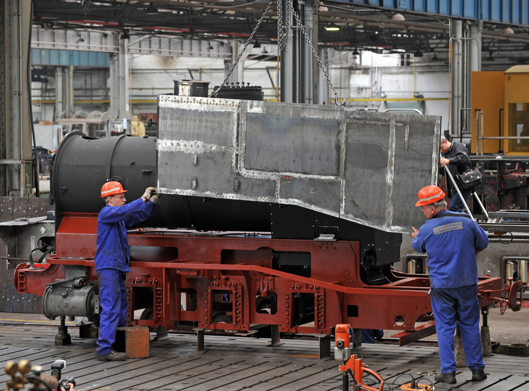 Zwei Arbeiter bei der Montage der Lok in der Werkhalle.