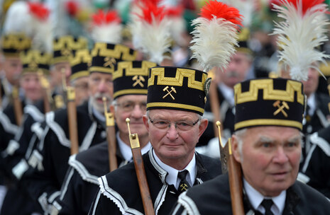 Bergmänner in festlicher Tracht während einer Parade.