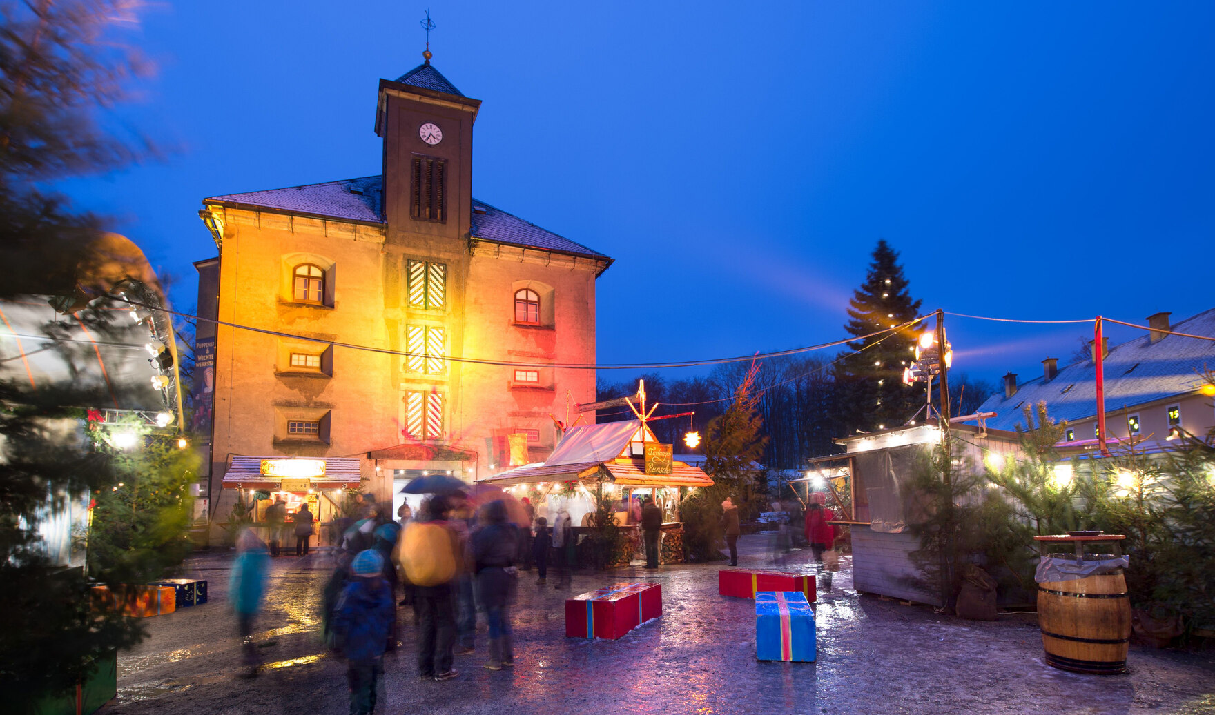 Besucher bummeln durch die Verkaufsstände des Weihnachtsmarktes, der umgeben ist von der historischen Kulisse der Festung.