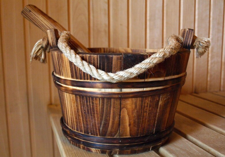 Ein Holzeimer mit einem großen Holzlöffel.